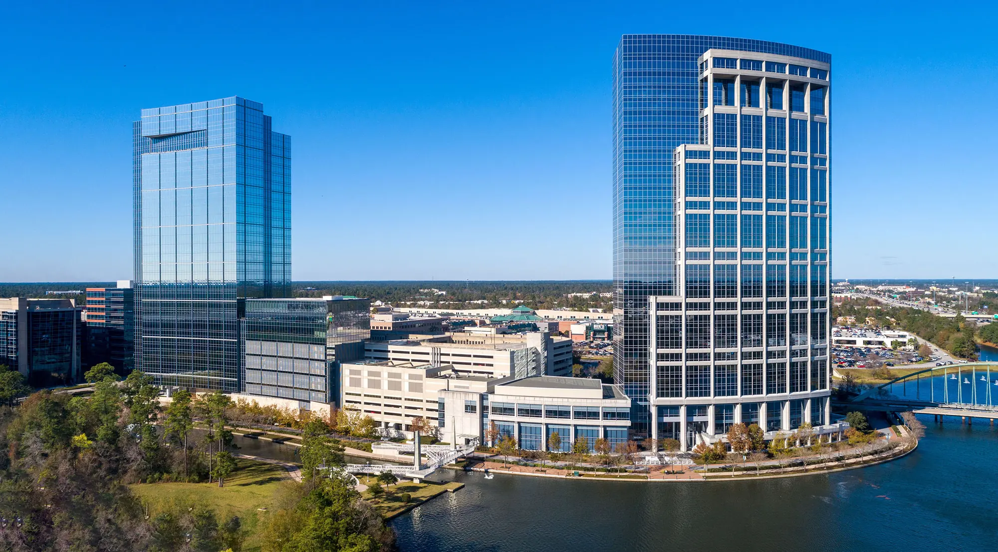 The Woodlands Towers and tree-lined Waterway in clear daylight