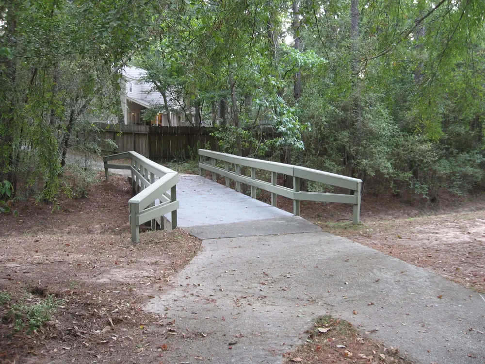 A shaded footbridge among trees in The Woodlands